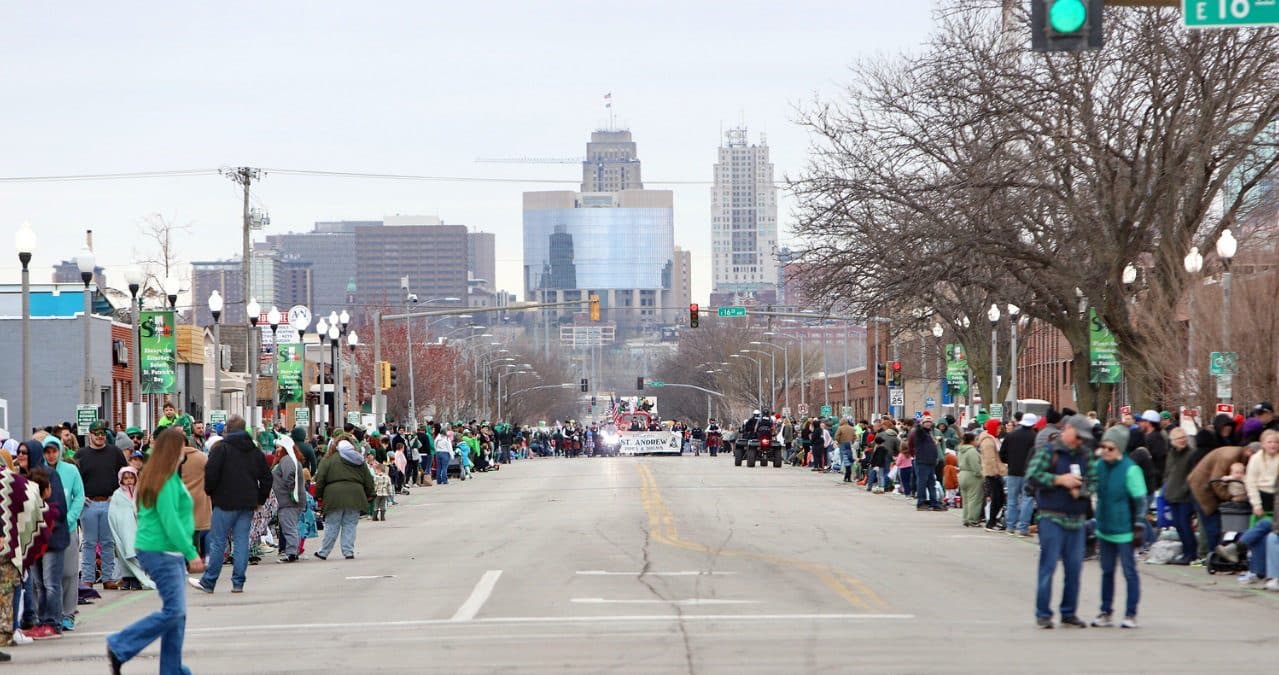 Swift Street lined with spectators, the Kansas City skyline behind